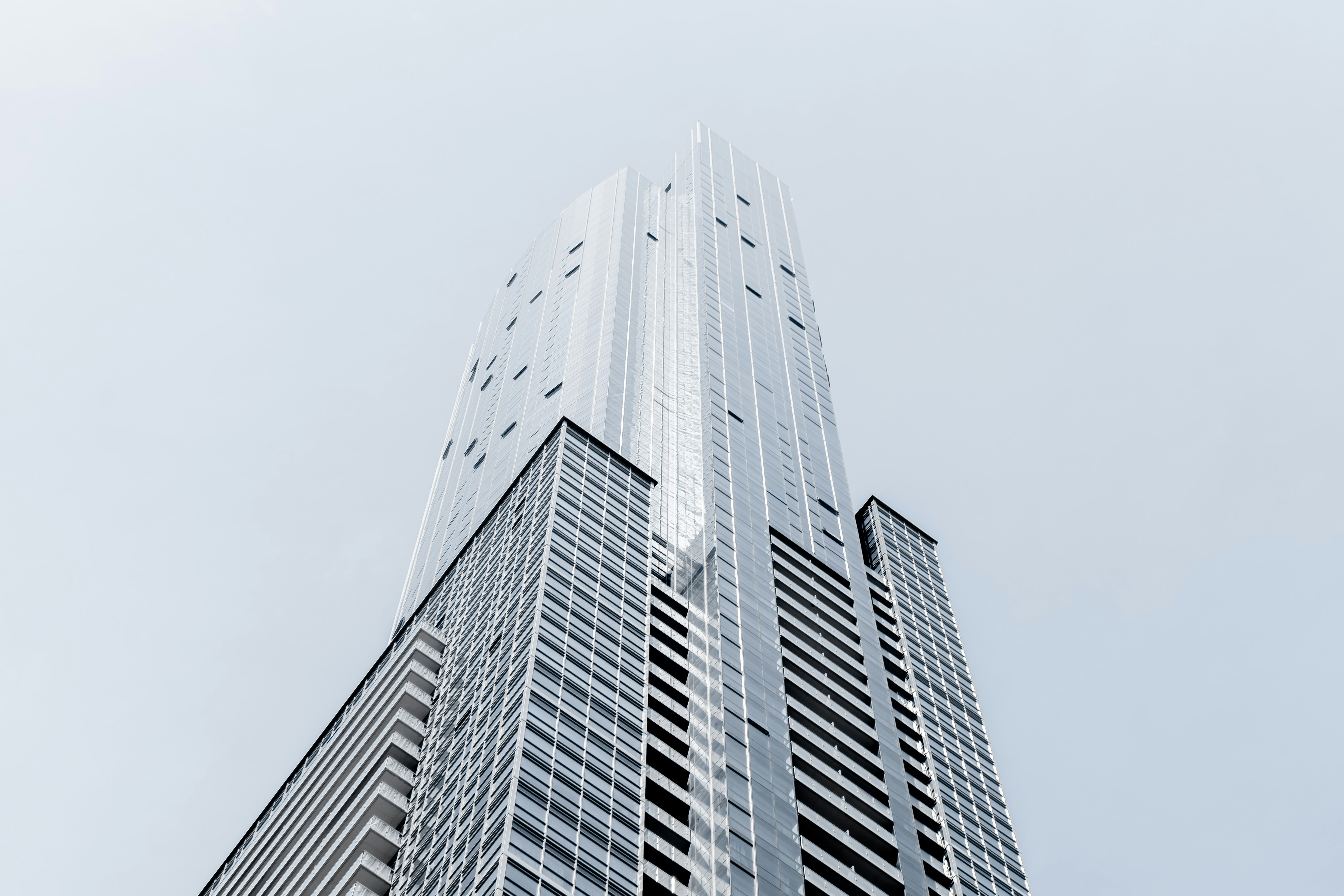 A tall skyscraper in Toronto against a pale blue sky